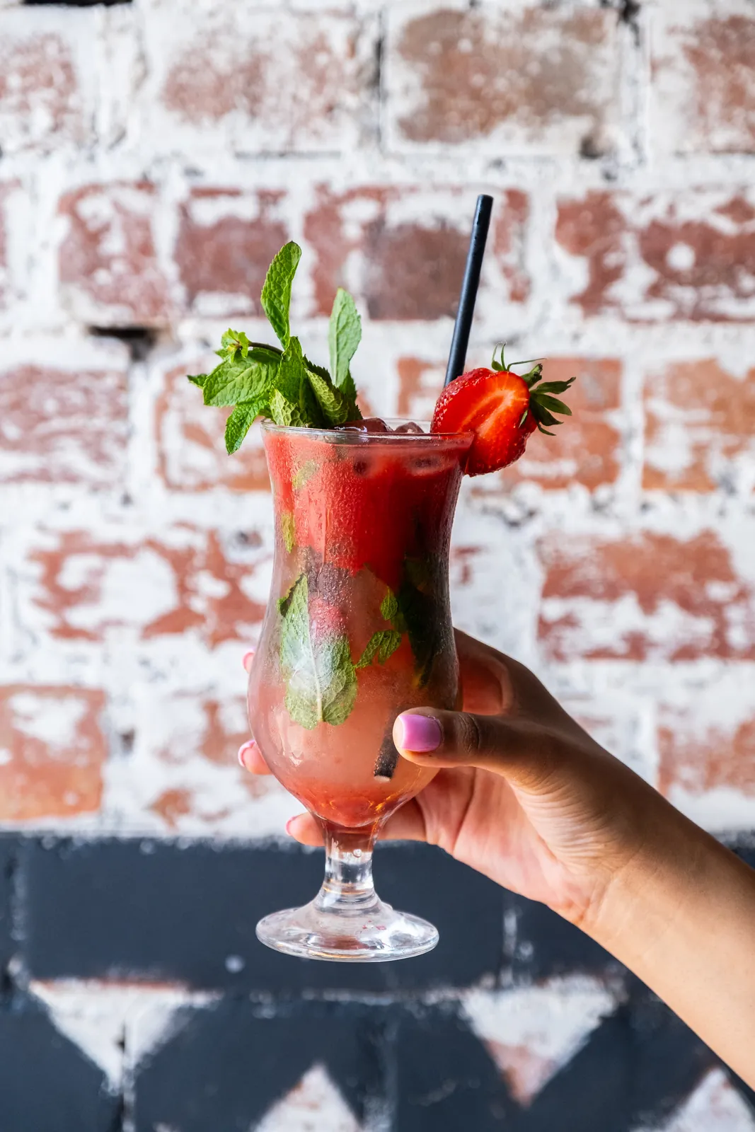 A red cocktail against the textured brick wall