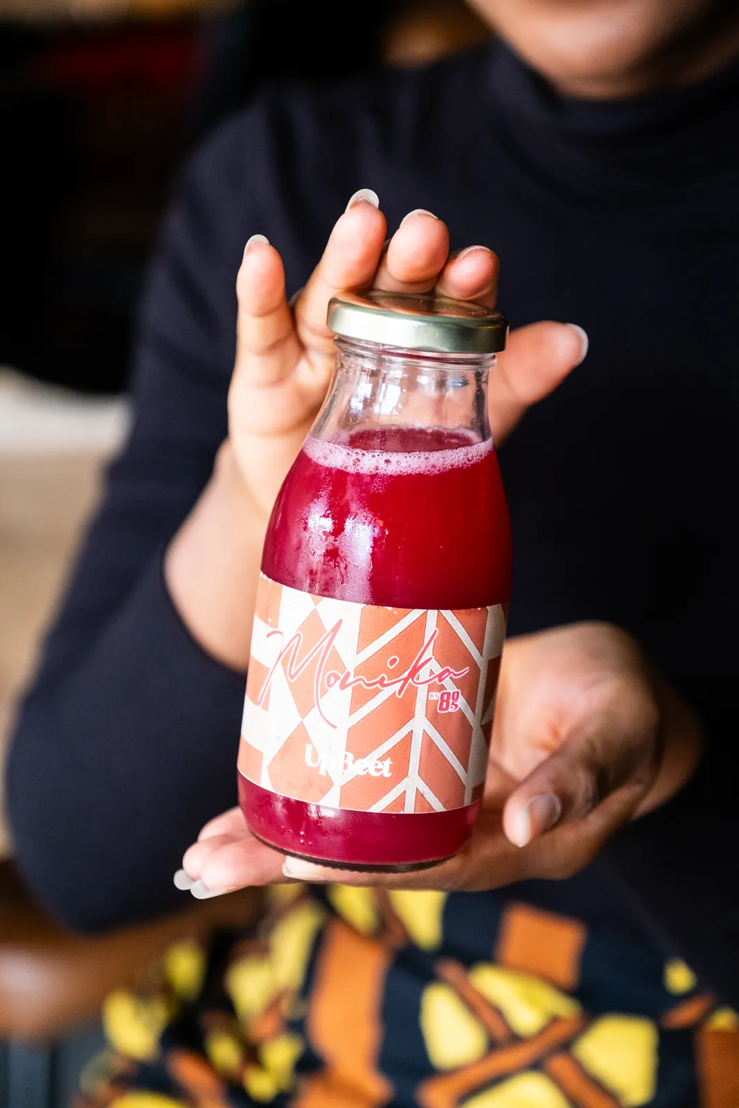 A bottled red drink presented by the team